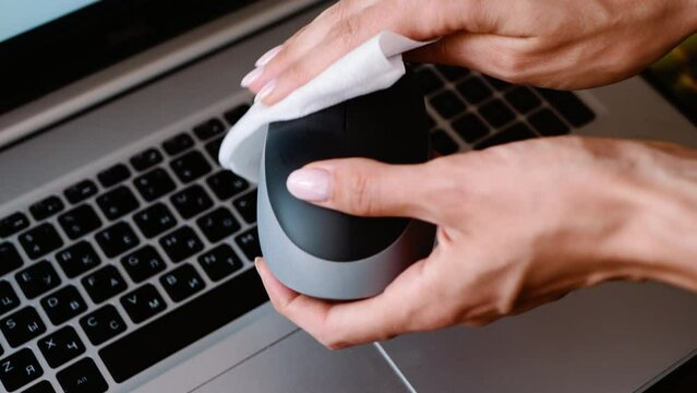 The computer mouse is wiped with a napkin. Office cleaning