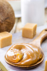 spoon of dulce de leche or homemade vegan pasty milk candy, caramel made with unsweetened coconut milk