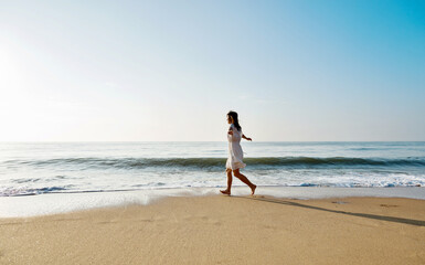 Young woman having fun walking on seaside.