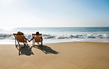 Couple sunbathing on a beach chair. - obrazy, fototapety, plakaty