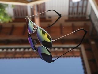 Fototapeta na wymiar Mirrored sunglasses reflecting on glassy surface