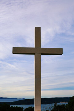 Cross on the background of the blue sky and the sea. Christian symbol.