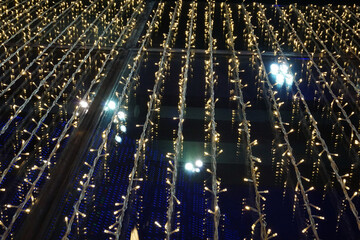 Naklejka premium Bokeh. Close-up Christmas tree. An abstract background of lights in the city at night.