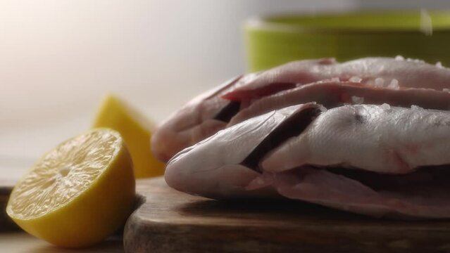 Seasoning Fish with Salt and Lemon for Cooking. Close-up, shallow dof.