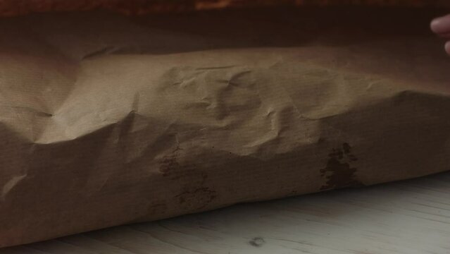 Unwrapping Fresh Fish from Brown Paper Package. Selective focus, close-up.