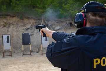 police officers practice shooting a pistol at a target