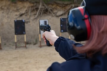 police officers practice shooting a pistol at a target - obrazy, fototapety, plakaty