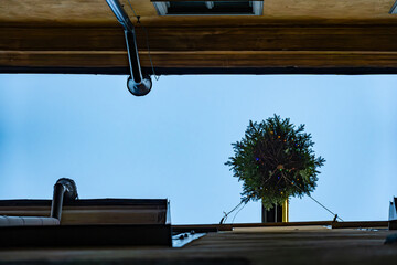 Stockholm, Sweden A Christmas tree with lights hangs over a small alley in the Old Town or Gamla...