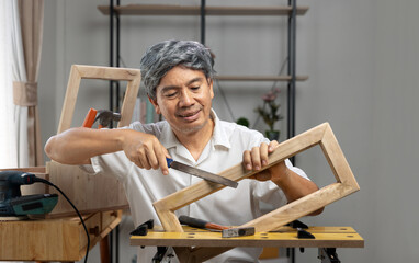 Woodworking hobby after Retirement. Senior man made a parts of woodwork  at home.