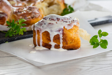 cooked baked sweet Cinnabon with cream in baking paper .