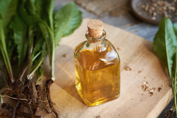 A bottle of dandelion root tincture with fresh plant