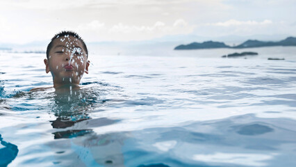 Boy swimming and spitting water from mouth