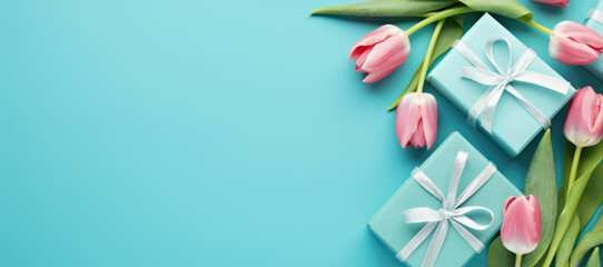 A bouquet of pink tulips and a gift box on a blue background. Spring greeting for birthday, Easter or Mother's day.