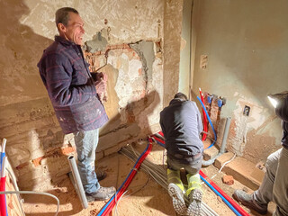 team of professional electricians is working at the construction site,operation specialists are...