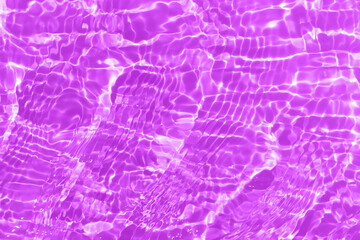 Purple water waves on the surface ripples blur. Defocus blurred transparent pink colored clear calm water surface texture with splash and bubbles. Water waves with shining pattern texture background.