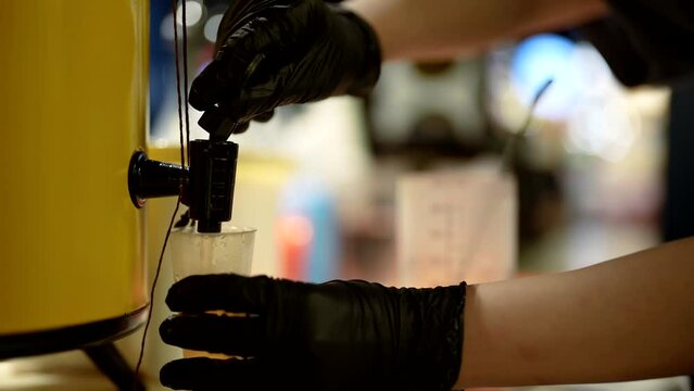 barman mixing ingredients for cocktail in measuring cup, closeup view of hands, cooking drinks