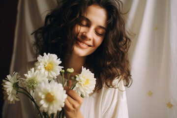 Obraz na płótnie Canvas Good looking caucasian woman smells flowers she is happy for get a fresh bouquet of white chrysanthemum