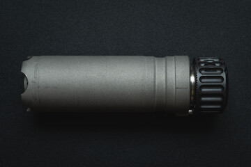 Part from a firearm, silencer from a rifle, close-up photo.