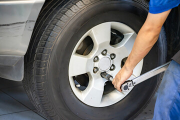 Auto mechanic using Torque wrench to inspection the wheel nuts for safety in travel in mechanics...