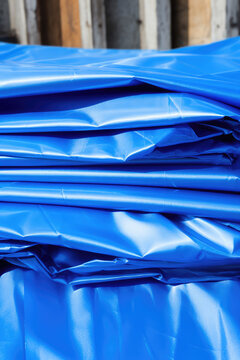 Protective blue tarpaulins for construction sites, water repellent films for repair and exterior construction work, awnings and canopies, vertical backdrop.