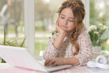 Cute and happy little girl children using laptop computer