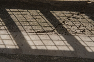 lower portion of iron gate sealed with net and its shadow on ground
