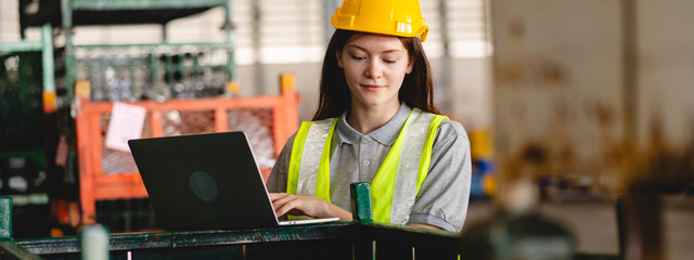 Female engineer using laptop computer for safety control checks or manufacturing maintenance work...