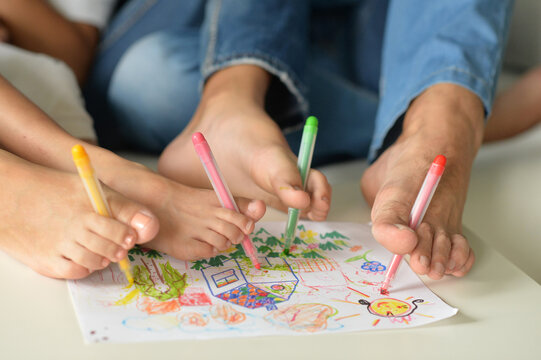 The family holds their pencils with their feet and draws 