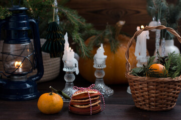 a Christmas tree with lights. A wicker basket with tangerines and dried orange slices, cones and Christmas tree toys