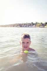 Happy child playing in the sea. Kid having fun outdoors. Summer vacation and healthy lifestyle...