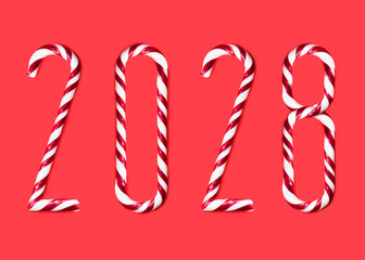 2028  made from sweet caramel canes, candies on red background