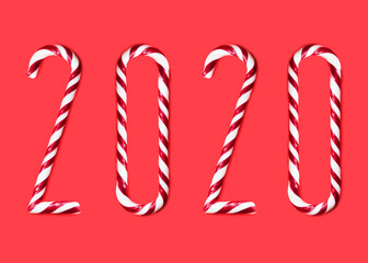 2020  made from sweet caramel canes, candies on red background