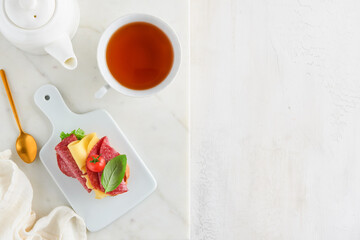 Salami sandwich. Delicious toasted sandwiches with slice salami, cheddar cheese lettuce and tomatoes cherry on white marble background. Restaurant menu, cafe, recipe or article concept. Mock up.