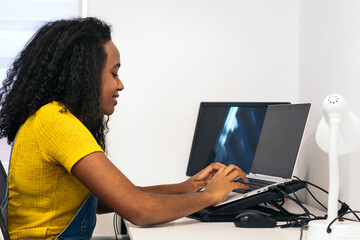 Young black woman working remotely with laptop