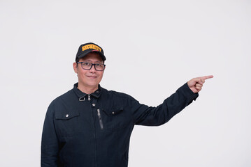 A friendly asian male security guard points to the right with his finger. Directing or advising...