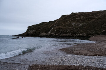 Fototapeta na wymiar Lulworth Cove and beach view at winter day. Lulworth Cove bay, beach and cliffs view . The Jurassic Coast is a World Heritage Site on the English Channel coast of southern England. Dorset, UK. public 