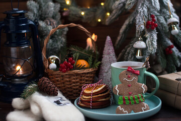 A Christmas tree with toys and a hot cup of orange tea. Warm white mittens and a gingerbread man