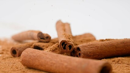 Close up studio shot of food ingredient. A pile of brown dried cinnamon sticks laying on the white background.