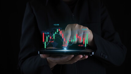 Businessman with mobile stock trading graph ,hands using mobile phone.