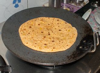 Cooking Indian paratha on tawa for breakfast 