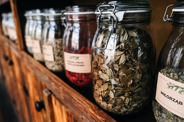 Glass Jars of Assorted Organic Freeze-Dried Foods on Wooden Shelf. Glass jars filled with various...