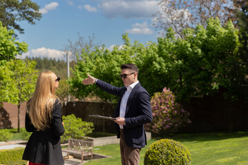 Real estate agent shows female client new residence illuminated by sunlight. Businesswoman inspects...