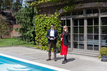 Blonde businesswoman inspects new house from real estate agency. Professional realtor tells...
