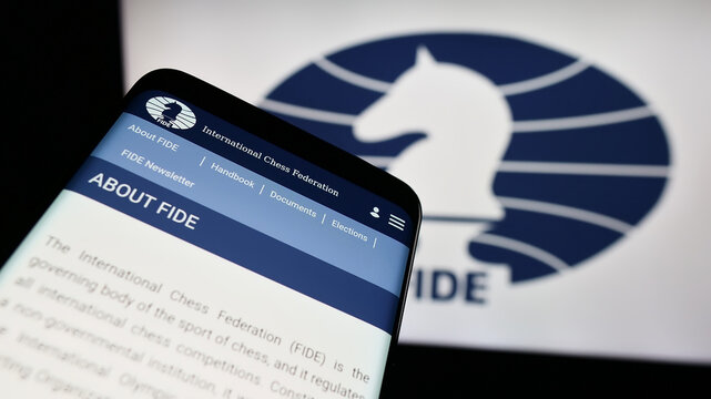 Stuttgart, Germany - 12-15-2023: Mobile phone with website of organisation International Chess Federation (FIDE) in front of logo. Focus on top-left of phone display.