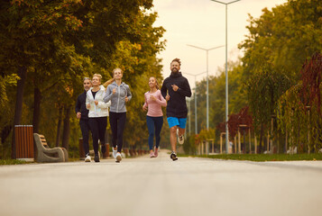 Group of diverse people having jogging workout in city streets. Five young and mature multiethnic...