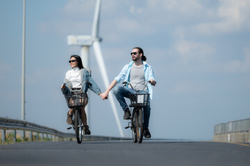 Young woman riding a bicycle with her boyfriend on the road