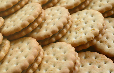 Detailed picture of round sandwich cookies with coconut filling. Background image of a close-up of several treats for tea