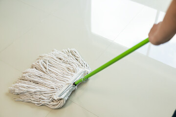 Maid wearing an apron provides cleaning services at home. Close-up of a young woman cleaning a new...
