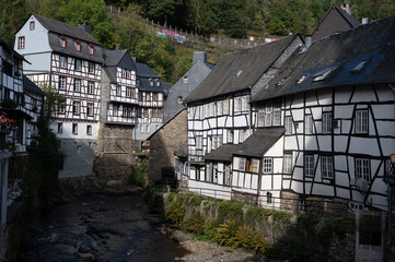 Fototapeta na wymiar View of houses and streets of old colourful German town Monschau in bend of the river and hidden between the hills, Eifel national park, Germany