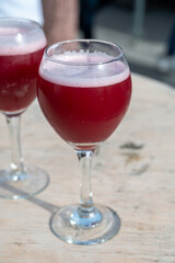 Famous fresh brewed red lambic kriek cherry beer served outside in Belgian beer festival in Durbuy,  special Belgian beer glass in sun lights